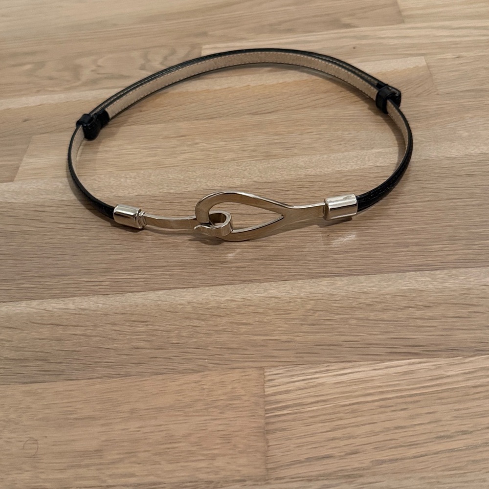 Adjustable length black leather belt featuring